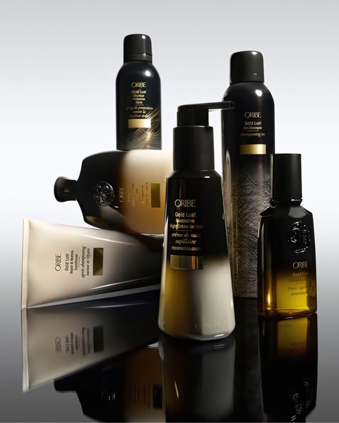 A high-end studio display of hair care products arranged for maximum visual impact, utilizing sophisticated lighting and deep reflections.