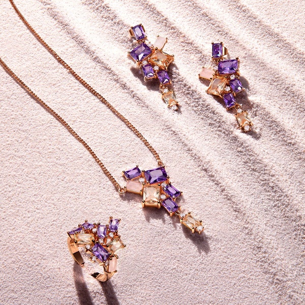A high-end jewelry set featuring a necklace, earrings, and ring displayed on a textured sand background, emphasizing light, shadow, and organic elegance.