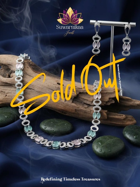 A high-end studio shot of a crystal necklace on driftwood with a bold Sold Out text overlay.
