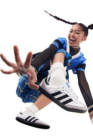 A high-energy, bottom-up angle of a model in motion, centering the Running Shoe as the primary focus while showcasing vibrant, casual streetwear.