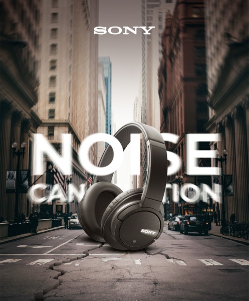 A sophisticated, high-contrast still life shot featuring noise cancellation headphones placed in the middle of a deserted, cracked urban street.