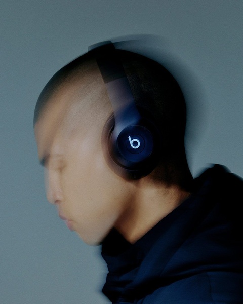 This creative features a close-up profile shot of a person wearing headphones with an intentional motion blur effect to emphasize focus and immersion.