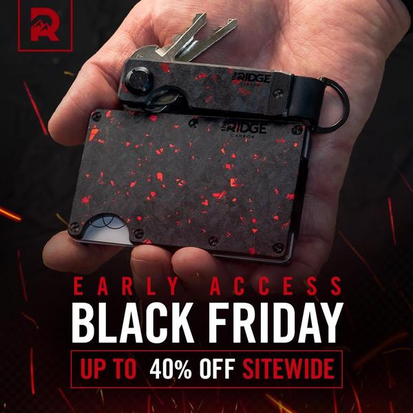 A close-up shot of a carbon fiber wallet and key organizer held in a hand against a dark, ember-filled background to highlight a seasonal sale.