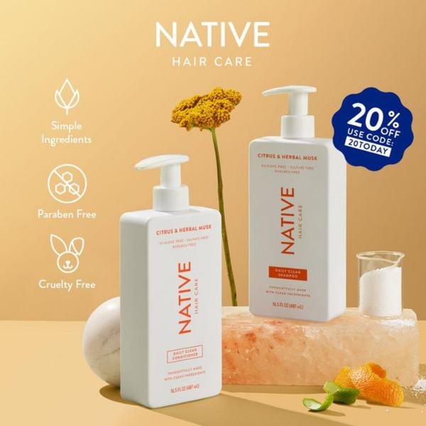A clean, studio-lit 1:1 image showcasing hair care products alongside natural ingredients like orange peel and sea salt to highlight simple, clean-ingredient benefits.
