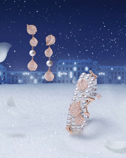 A sophisticated, high-end display of pearl and diamond earrings and a bracelet set against a wintry, snowy background.