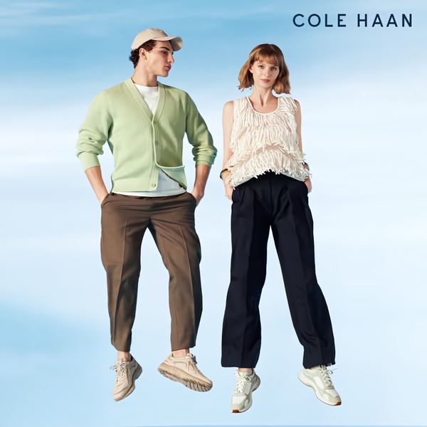 A high-key studio shot featuring a man and a woman mid-jump wearing casual outfits and running shoes, set against a simple light blue gradient background.