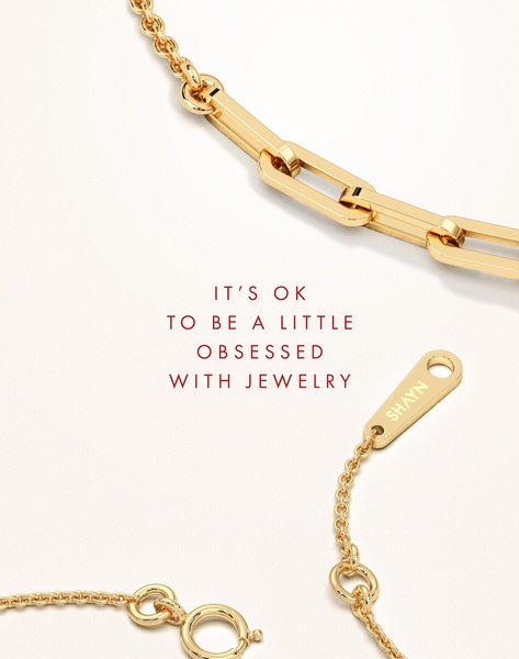 A close-up high-key shot of a gold chain necklace featuring a playful, brand-focused emotional headline on a clean white background.
