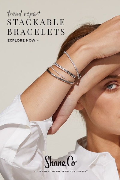 A clean, editorial-style product hero image featuring a stack of metallic bracelets on a wrist, designed for a professional and sophisticated brand look.
