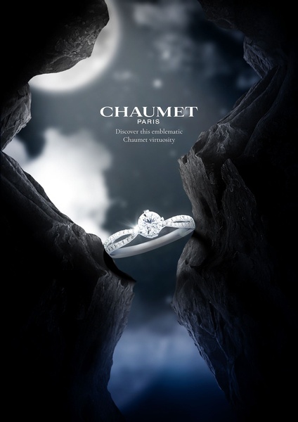 A high-end diamond ring is suspended between two dark rock formations under a full moon, using high-contrast cinematic lighting to emphasize luxury.