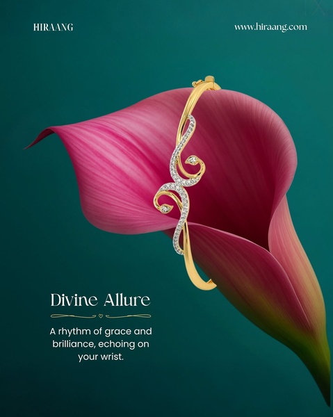 A elegant gold and diamond bangle bracelet is displayed resting on a vibrant pink lily petal against a deep green background.