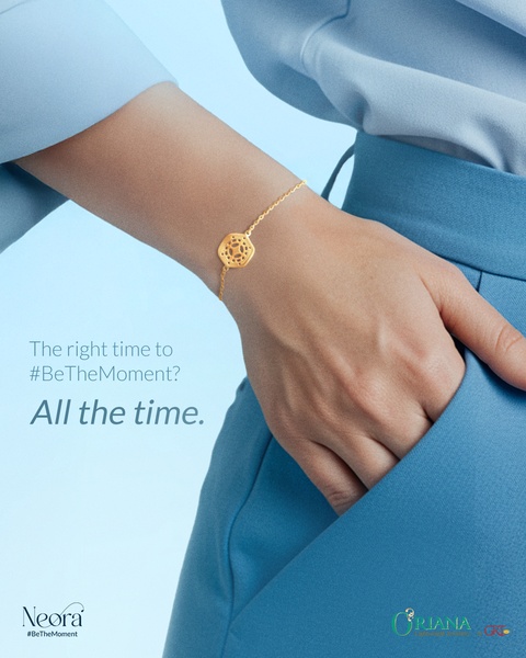 A close-up shot of a wrist wearing a delicate gold bracelet, styled with blue clothing and minimalist copy.