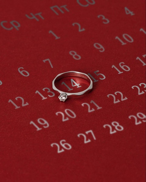A single engagement ring sits on the 14th day of a calendar, using a date-specific visual hook to drive immediate association with romantic gifting.
