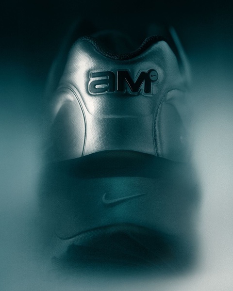 A low-angle, high-contrast product shot of a running shoe heel, emphasizing texture, branding, and a moody, atmospheric lighting style.