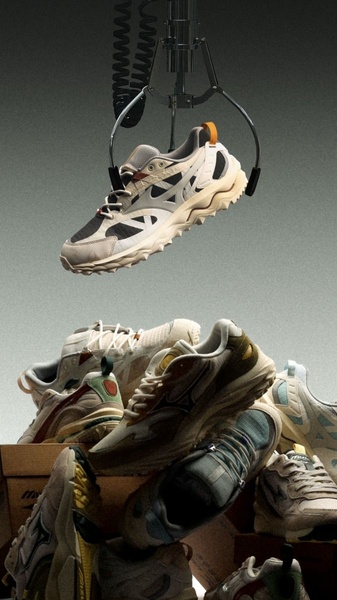 A high-end product photography shot featuring a running shoe being plucked from a pile of footwear by a mechanical claw in a studio setting.