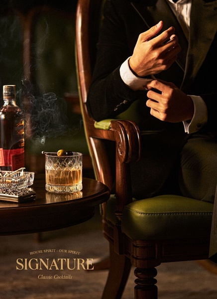 A high-end, lifestyle-oriented ad featuring a close-up of a gentleman in a suit enjoying a premium cocktail, emphasizing sophistication and quality.
