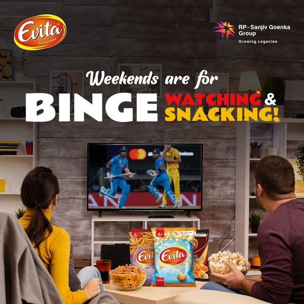 A lifestyle-focused ad creative showing a couple enjoying popcorn and snacks while watching sports on a television, emphasizing the snack-and-screen ritual.