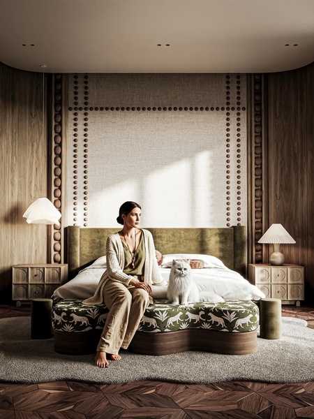 A high-quality lifestyle shot featuring a model and a cat on a luxury upholstered bed in a warm, textured interior setting.