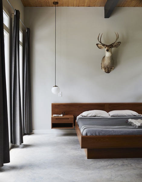 A high-end bedroom shot featuring a wood-frame floating platform bed, soft ambient lighting, and neutral color tones for a premium aesthetic.