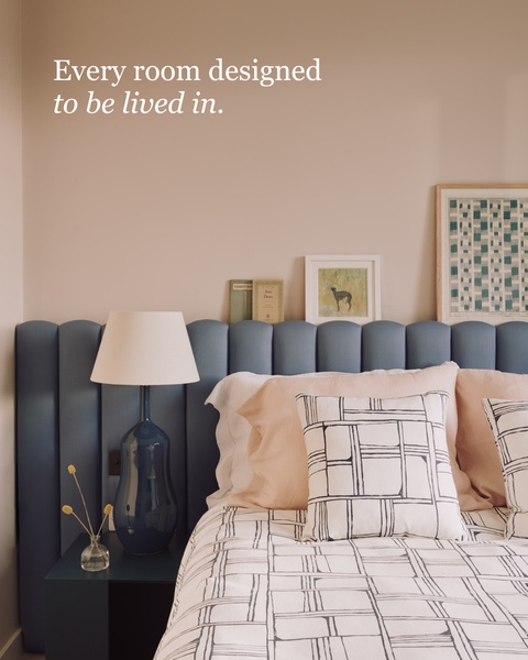 A high-quality lifestyle shot of an upholstered bed headboard featuring neutral tones and aspirational, clean design.