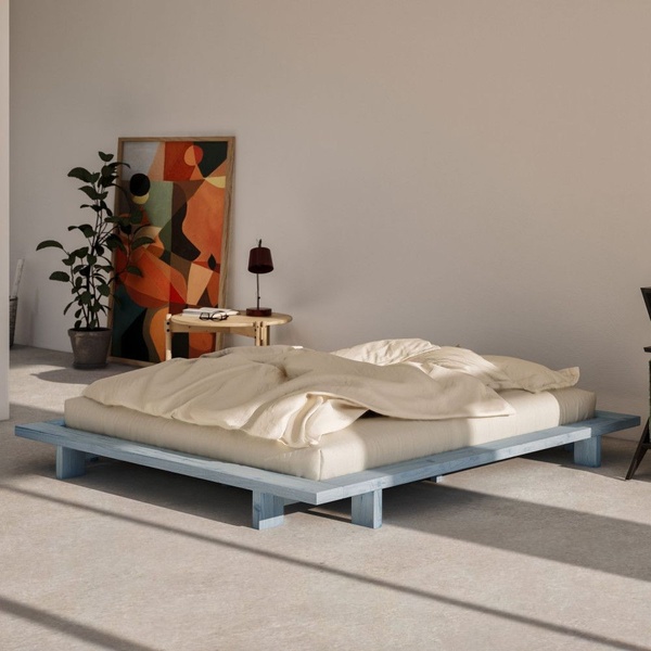 A clean, eye-level shot of a wooden platform bed in a spacious room, utilizing natural light and intentional negative space to emphasize the product design.