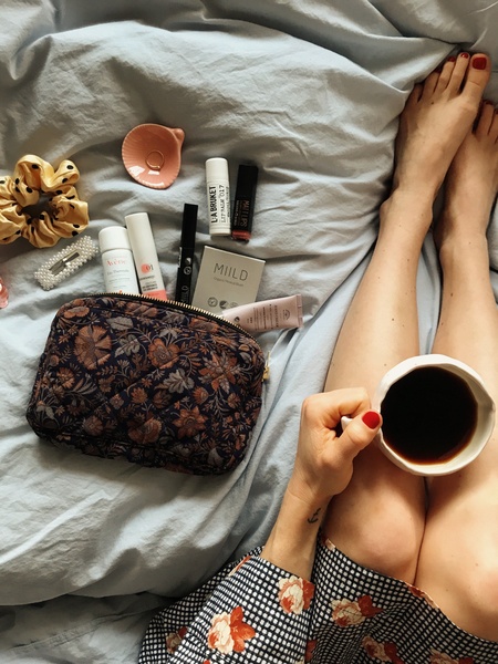 cosmetics pouch, skincare products, makeup bag, beauty essentials, hand cream, lip balm, facial blush, brand awareness, lifestyle, flat lay, calm, warm, neutral, blue
