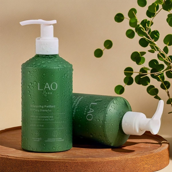 A high-quality, professional product hero shot of Purifying Shampoo bottles on a wooden surface with subtle water droplets, evoking freshness and organic ingredients.