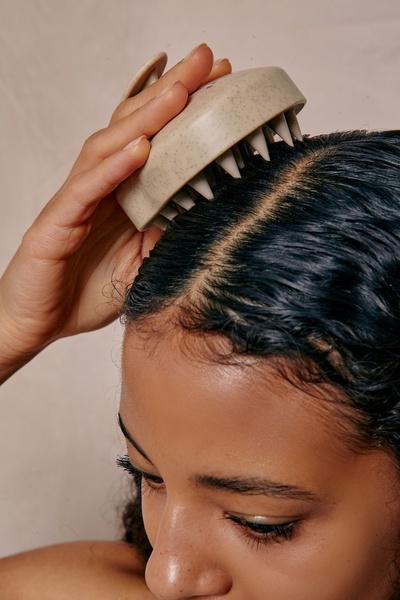 A close-up, high-resolution shot showing a Scalp Massager being used to massage the scalp, focusing on ease of use and product ergonomics.