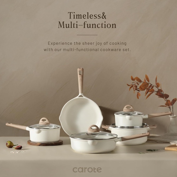 A high-end product photography shot of a multi-piece white ceramic cookware set with wooden handles against a soft, textured earth-tone backdrop.