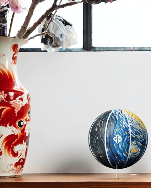 A high-end studio photograph featuring a Starry Night-inspired basketball positioned next to an ornate red and white ceramic vase, emphasizing texture and artistic design.