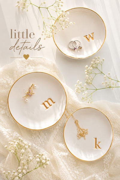 A high-end, clean-aesthetic product shot featuring personalized jewelry dishes decorated with baby's breath flowers.