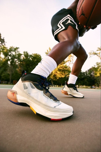 A low-angle, high-energy shot of a basketball player mid-pivot, highlighting the detail and tread of the sneaker in an outdoor court setting.