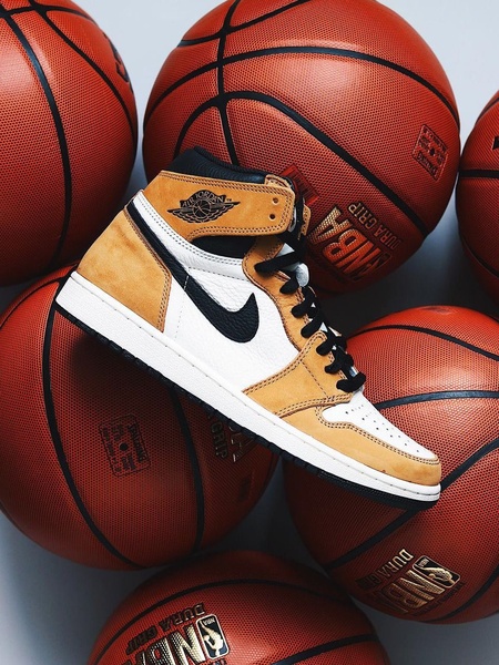 A high-quality studio close-up of a basketball sneaker centered among several basketballs, emphasizing texture and athletic lifestyle.