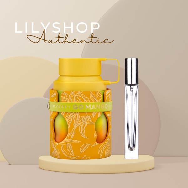 A high-quality studio shot of a mango-scented perfume bottle and travel-sized atomizer set against a clean, layered minimalist background.