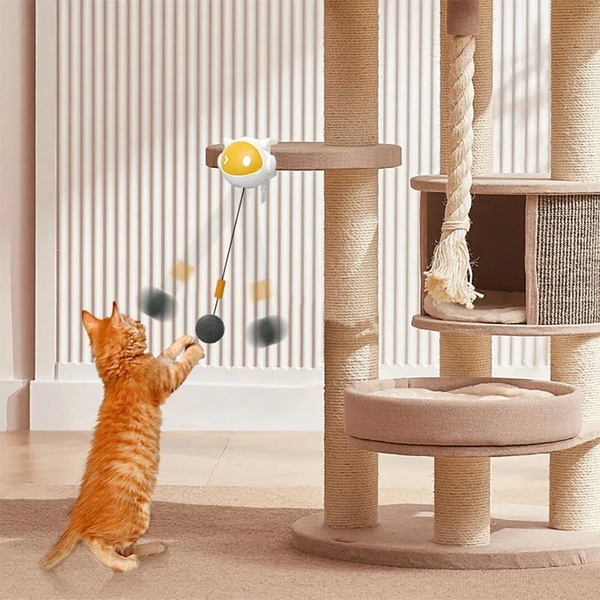 This creative showcases an automated interactive cat toy mounted on a cat tree, featuring a cat actively batting at the moving attachment.