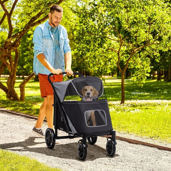 A man strolls through a sunlit park with his dog inside a mesh-covered dog stroller, emphasizing comfort and outdoor activity.