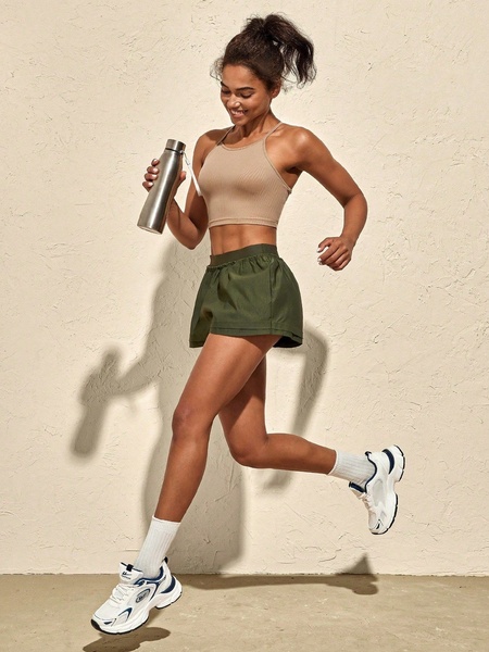 A high-quality studio shot of a model in activewear, showcasing a running shoe in a dynamic, mid-air motion to highlight product features.
