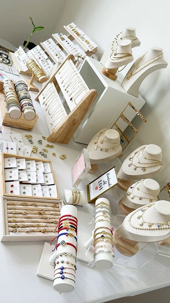 An organized, top-down tabletop shot showcasing a full collection of bracelets, necklaces, and earrings arranged for high visual appeal.