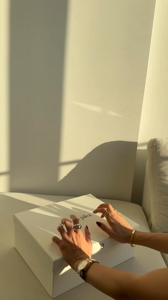 A close-up shot of hands resting on a clean white jewelry box during golden hour, highlighting elegance and anticipation.