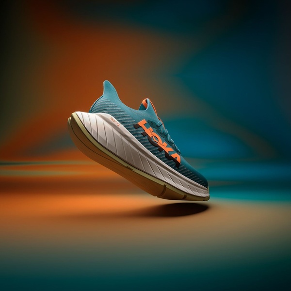 A high-performance running shoe is captured mid-air against a soft, gradient-lit studio background to emphasize sleek design and lightness.