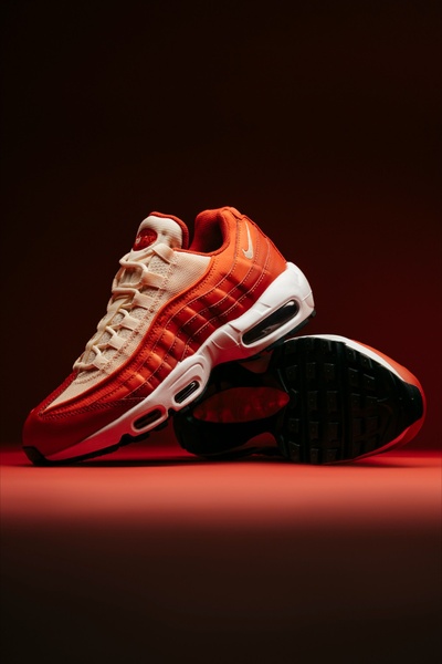 This ad creative features a high-end studio shot of a running shoe using a monochromatic, warm-toned lighting setup to emphasize product detail.