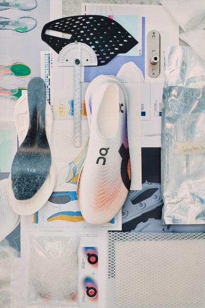 A flat-lay perspective displaying the individual components, materials, and measurement tools used to engineer a modern high-performance running shoe.