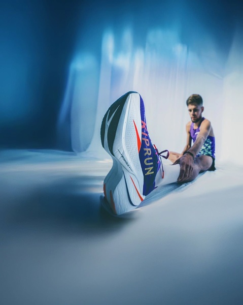 This ad creative features an extreme low-angle close-up of a high-performance running shoe on an athlete, emphasizing the product profile against a moody, ethereal backdrop.