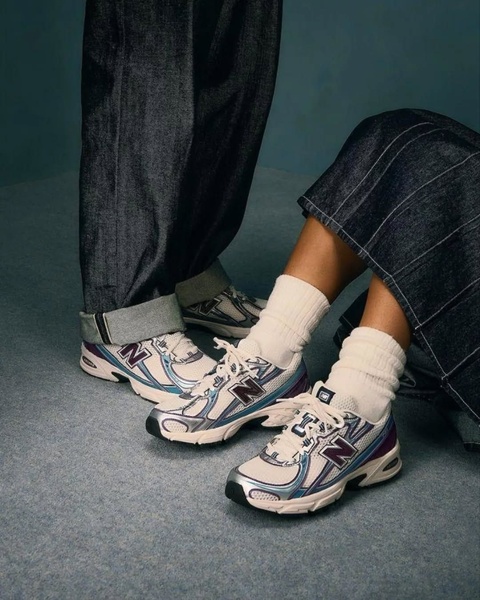 A close-up, low-angle shot focusing on the texture and design of a modern running shoe worn with casual, high-quality denim and socks.