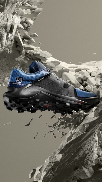 A striking vertical ad featuring a running shoe seemingly suspended in a rocky, crumbling mountain terrain.