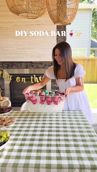 A high-quality lifestyle shot showcasing a beverage tub filled with ice and sodas, prepared by a smiling host for a social gathering.