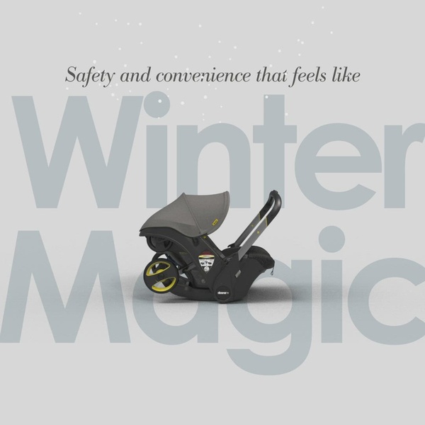 A minimalist, high-contrast product display focusing on a grey infant car seat centered against a soft grey background with subtle seasonal text elements.