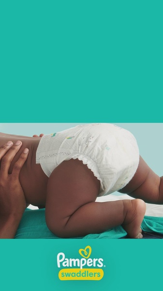 A close-up, bottom-up perspective of a baby in a diaper, set against a solid teal background that emphasizes the product as the sole focus of the creative.