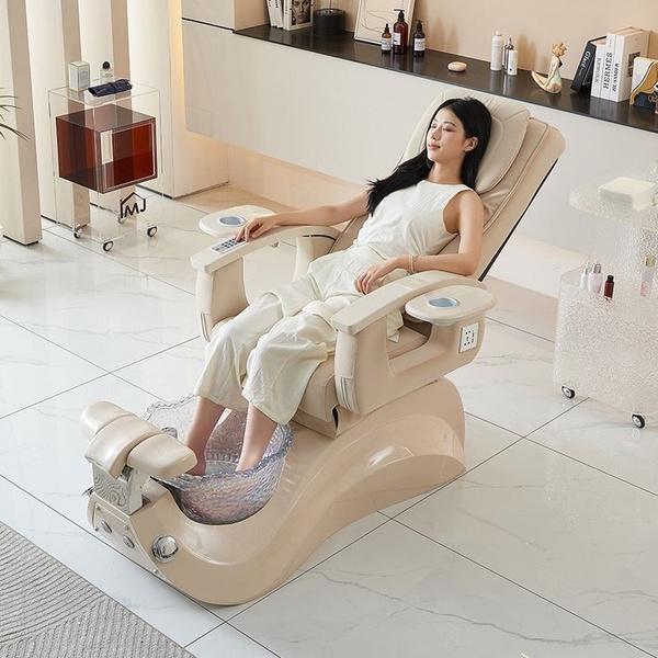 This 1:1 square creative features a clean, high-end studio shot of a model relaxing in a premium pedicure chair, emphasizing an aspirational and tranquil mood.