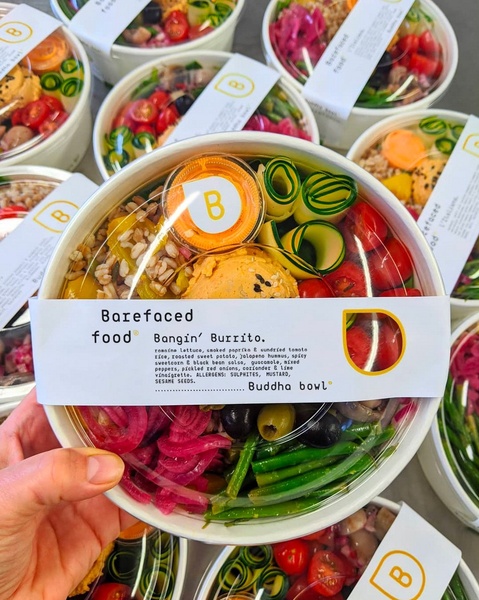 A high-clarity, top-down shot of a Buddha Bowl featuring a clear label describing ingredients, presented in a clean, minimalist culinary style.