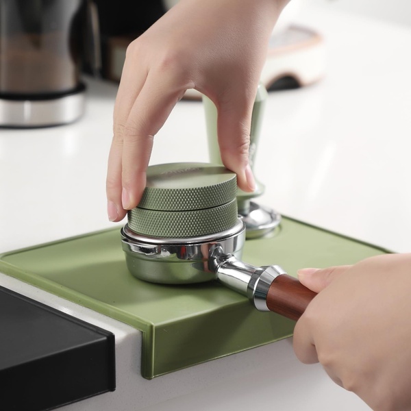 A close-up shot showcasing the precision manual distribution of coffee grounds in a portafilter using a high-quality coffee distributor tool.